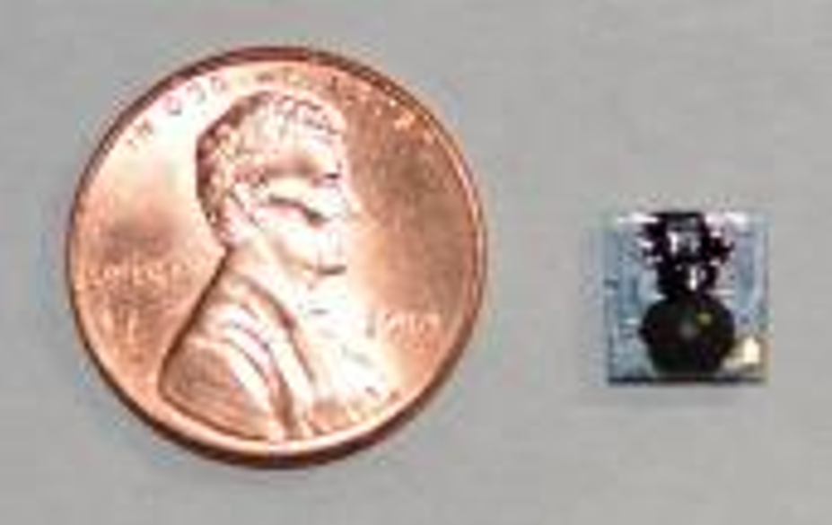 Complete 128-milligram optical-flow sensor assembly beside a penny