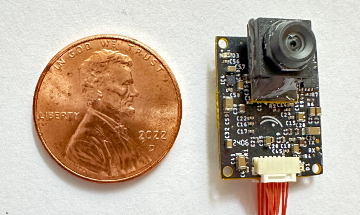 Complete recent 980-milligram Centeye vision sensor beside a penny